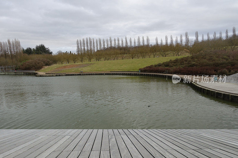 Wooden terrace in front of a pond in a public park  Pedestrian path for hiking  Île de France  Winter season